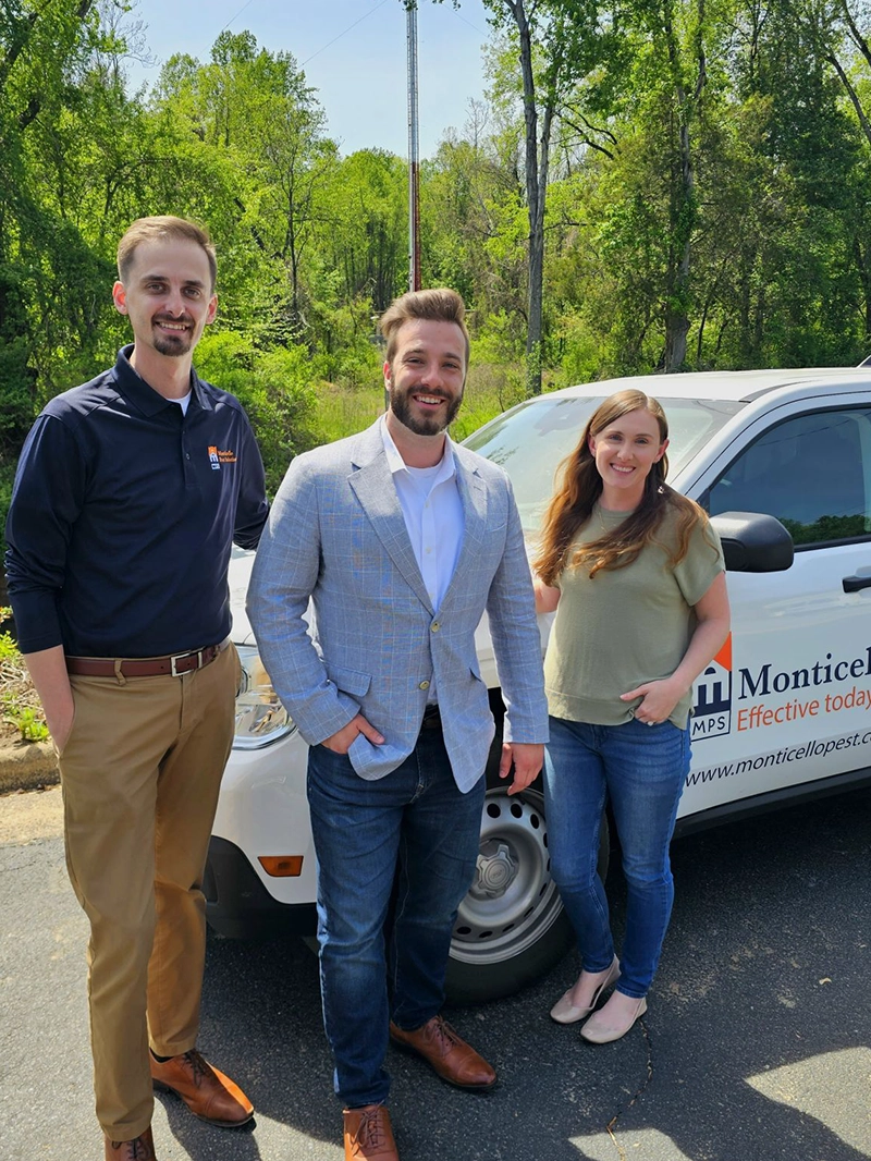Three people are positioned next to a MPS truck, showcasing a casual outdoor moment together